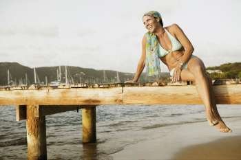 Mid adult woman sitting on a pier and smiling