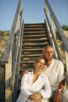 Mature couple sitting on a staircase and looking away