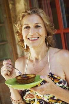 Portrait of a mature woman eating a tart