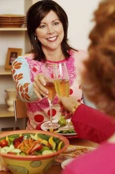Mature woman and her friend toasting with champagne flutes