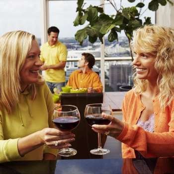 Mature woman with a mid adult woman toasting a drink