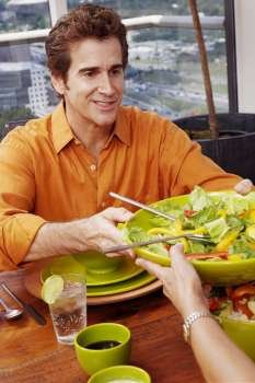 Mature man giving a plate of salad