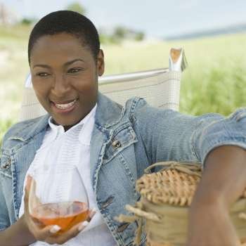 Close-up of a mid adult woman holding a glass of wine and smiling
