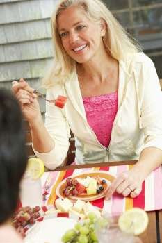 High angle view of a mature woman eating fruit salad