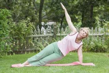 Mature woman exercising in a lawn