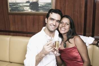Young couple toasting with champagne flutes and smiling