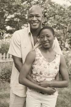 Portrait of a mature man embracing a mid adult woman and smiling
