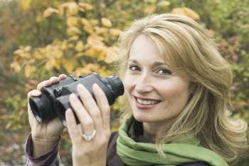 Portrait of a mature woman holding binoculars and smiling