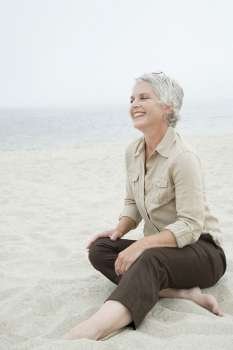 Mature woman sitting on the beach