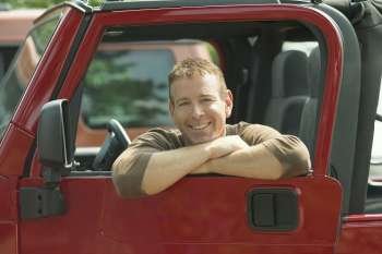 Portrait of a mature man in a jeep and smiling