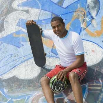 Portrait of a mature man sitting on a skateboard ramp