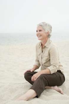 Mature woman sitting on the beach