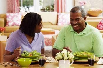 Close-up of a mature couple eating salad and smiling