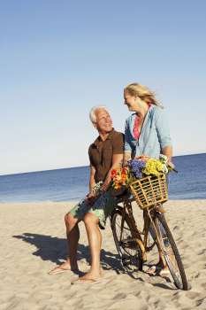 Mature couple with a bicycle on the beach