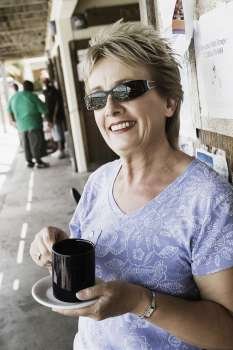 Close-up of a mature woman holding a cup of coffee