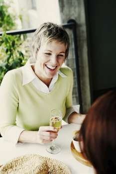 Mature woman holding a champagne flute and smiling with her friends