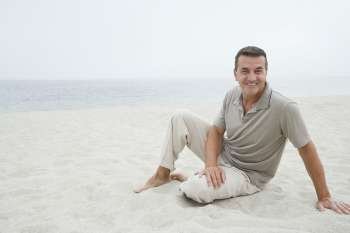 Portrait of a mature man sitting on the beach and smiling