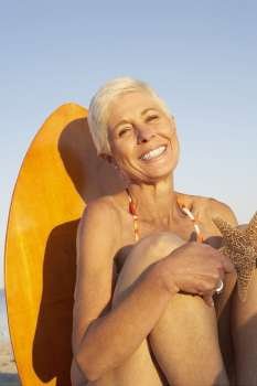 Portrait of a mature woman holding a starfish and smiling