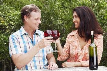 Close-up of a mature couple toasting glasses of wine and smiling