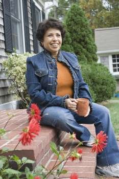 Mature woman sitting on steps and smiling