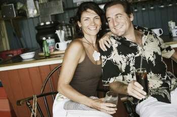 Close-up of a mid adult couple holding glasses of drink in a restaurant