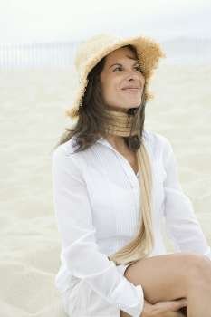 Mature woman sitting on the beach and smirking