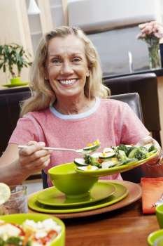 Portrait of a mature woman holding a plate of salad