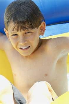 Portrait of a boy with an inflatable ring in a swimming pool
