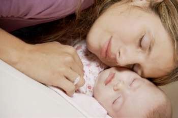 Close-up of a young woman sleeping with her daughter