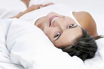 Portrait of a young woman lying on the bed and smiling