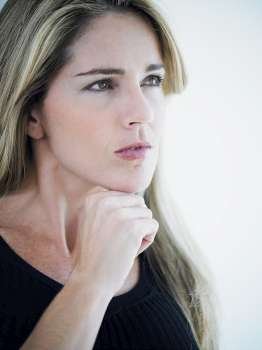 Close-up of a mid adult woman thinking with her hand on her chin