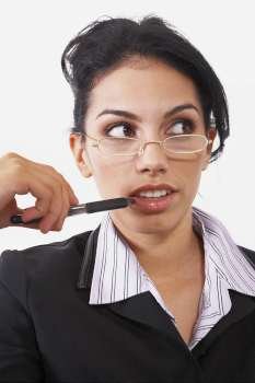 Close-up of a businesswoman holding a pen and thinking