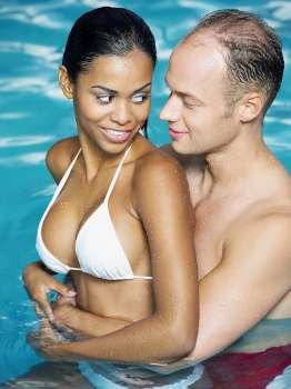 Side profile of a young couple embracing each other in the swimming pool