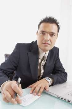 Portrait of a businessman holding a pen and a check