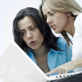 Close-up of a mid adult woman and a mature woman working on a laptop