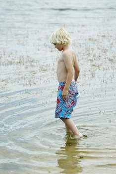 Side profile of a boy standing in water