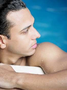 Close-up of a young man leaning on the edge of a swimming pool