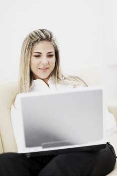 Mid adult woman using a laptop and smiling