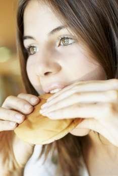 Close-up of a young woman eating a burger