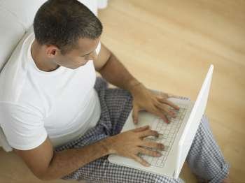 High angle view of a mid adult man using a laptop