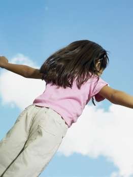 Rear view of a girl with her arms outstretched