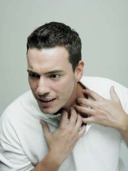 Close-up of a mid adult man touching his neck