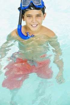 Portrait of a boy with a scuba mask on his head in a swimming pool