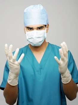 Portrait of a male surgeon wearing a surgical mask and surgical gloves