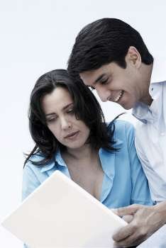 Mature woman and a mid adult man looking at a laptop