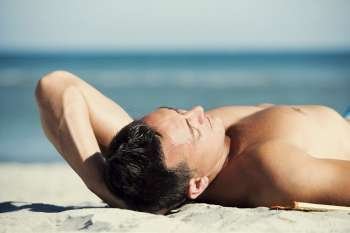 Young man lying on the beach