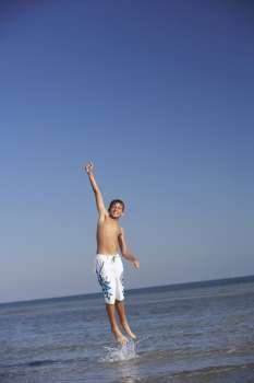 Teenage boy jumping in the sea