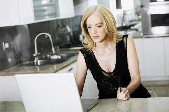 Mid adult woman using a laptop in a kitchen