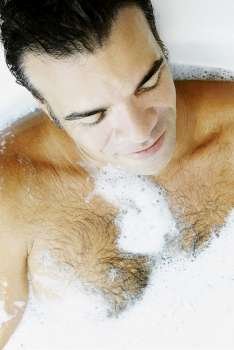 Close-up of a mature man taking bubble bath