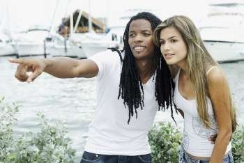 Close-up of a young man and a young woman pointing forwards